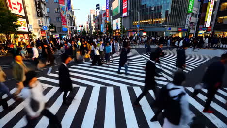 people crossing a busy street in a japanese metropolis