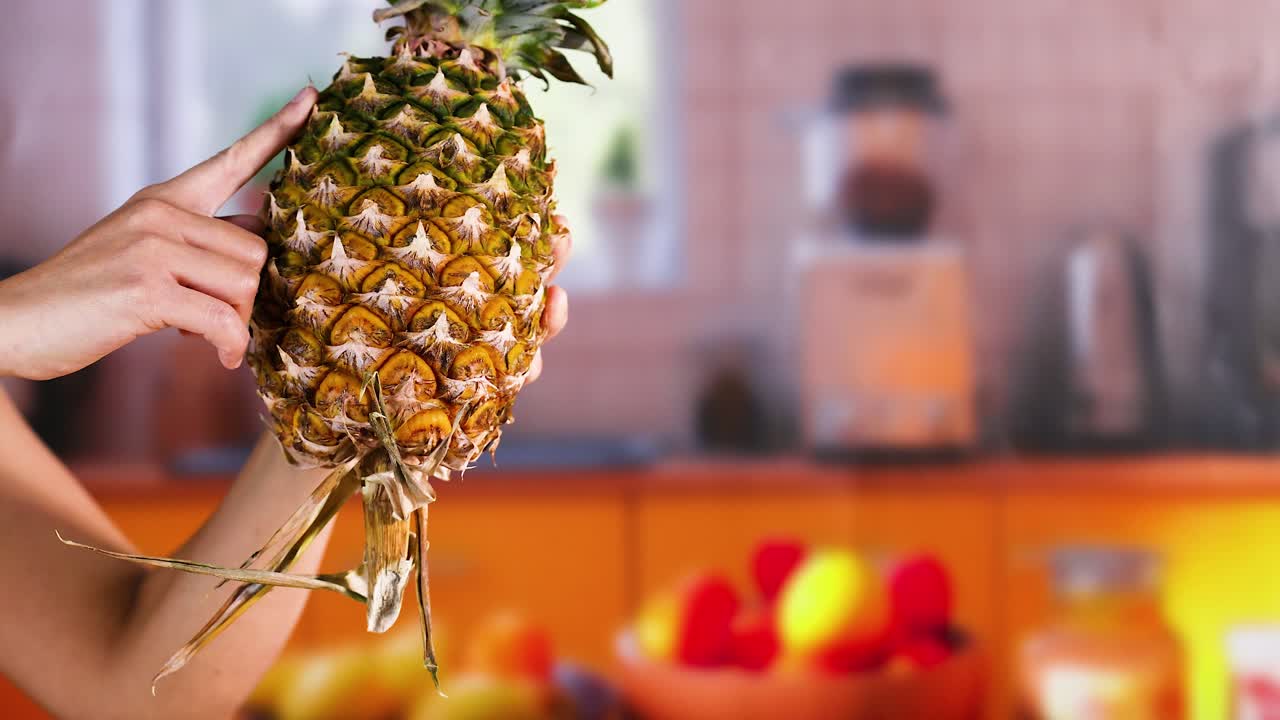 persona señalando una piña en una cocina