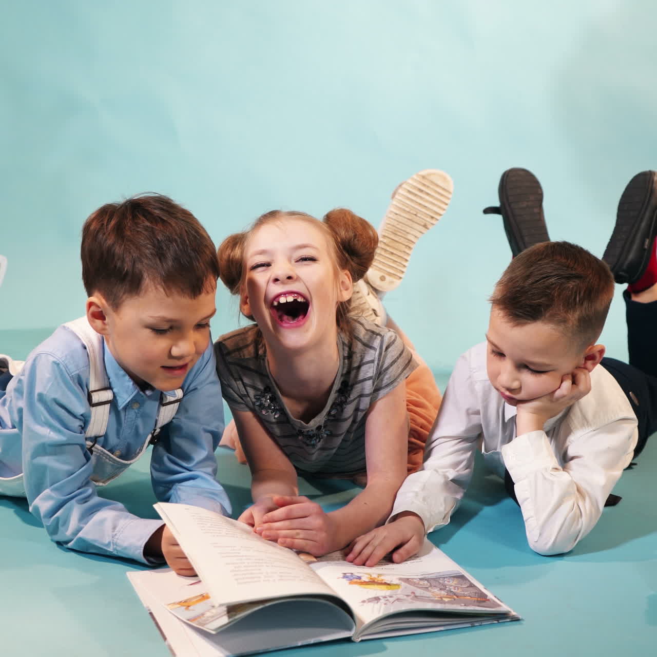 Crowd of children reading a book. Concept of a happy childhood Square video