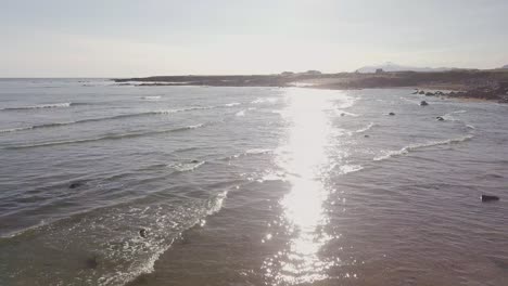 Low-Flight-Over-a-Rocky-Beach-and-the-Ocean-in-Sunshine-During-Sunny-Summer-In-Snaefellsness-Peninsula,-Iceland