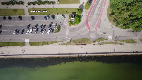 top down view of seaside boulevard in gdynia poland, road intersection, outside cars parking and people tourists walking around by the sea shore, water front summer cityscape