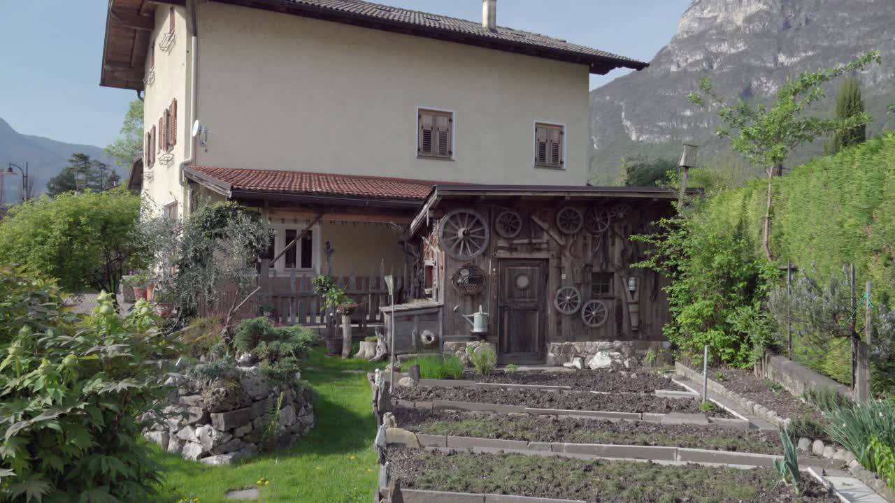 Zooming out of a garden, a shed and a house in spring, Kurtinig - Cortina, South Tyrol, Italy