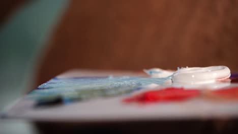 artist painting with brush on palette