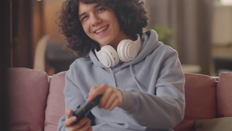 teenager playing game on console at home