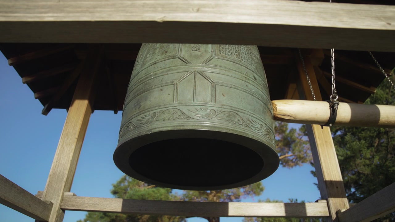 Tronco che colpisce la vecchia campana del tempio giapponese