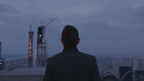 a man stands outside in a city at night