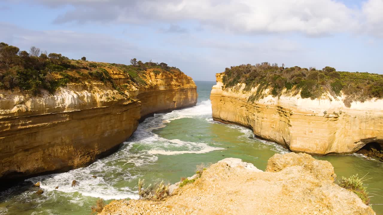 Loch Ard Gorge's majestic cliffs and turquoise waters under bright daylight. Captured at Port Campbell, Australia, showcasing natural beauty and rugged coastline