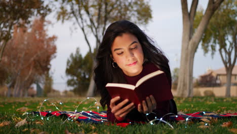 una joven atractiva abriendo las páginas de un libro y leyendo un capítulo de la historia desliza hacia la derecha