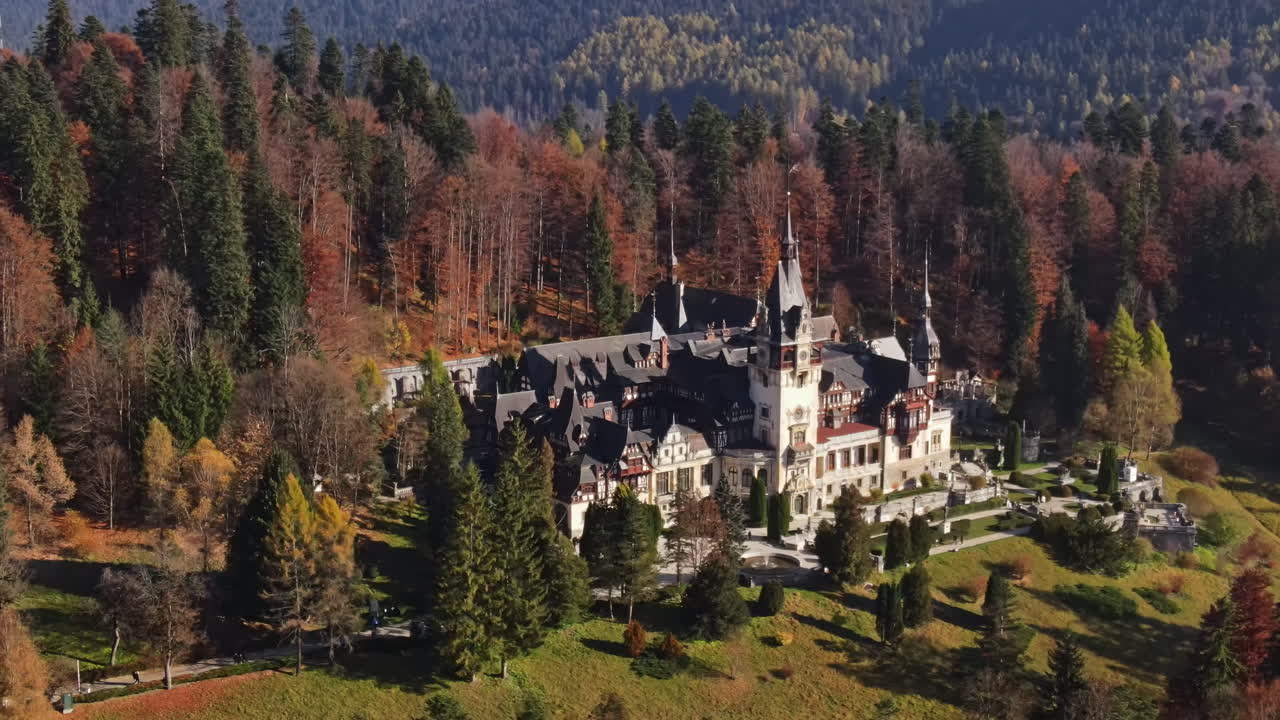 Aerial drone view of The Peles Castle in Romania. Castle with gardens in Carpathians, forest around it, tourists