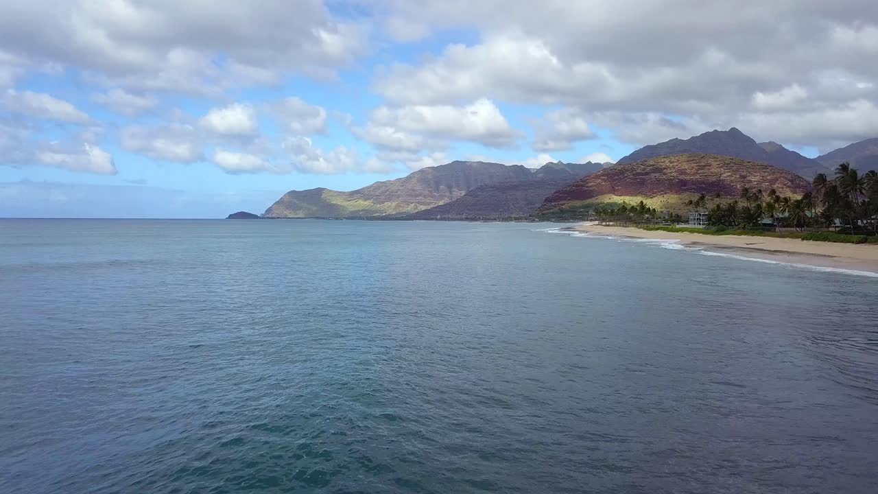 Cielo nuvoloso sul lato ovest di Oahu, Hawaii, con onde oceaniche che si infrangono sulla spiaggia.