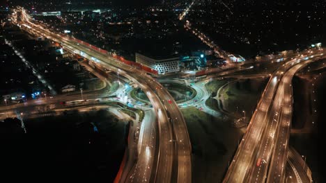 aerial drone time lapse hyperlapse car traffic roundabout circle interchange road at night, top view junction highway intersection in evening. flyover cityscape driving busy junction crossroad