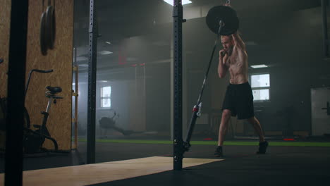 Slow-motion:-Man-doing-Single-Arm-Landmine-Squat-to-Press-exercise.-Young-man-lifting-barbell-with-light-weights-at-gym