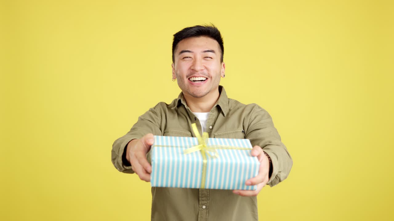 Happy Asian Man Smiling and Presenting a Gift