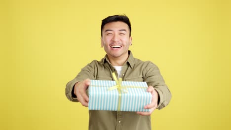 happy asian man smiling and presenting a gift