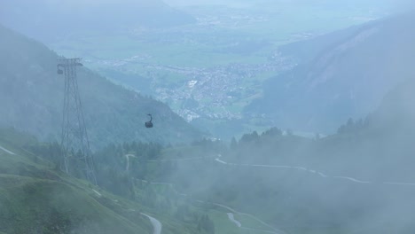 cable cars cutting throw the fog covered sky heading upwards and down