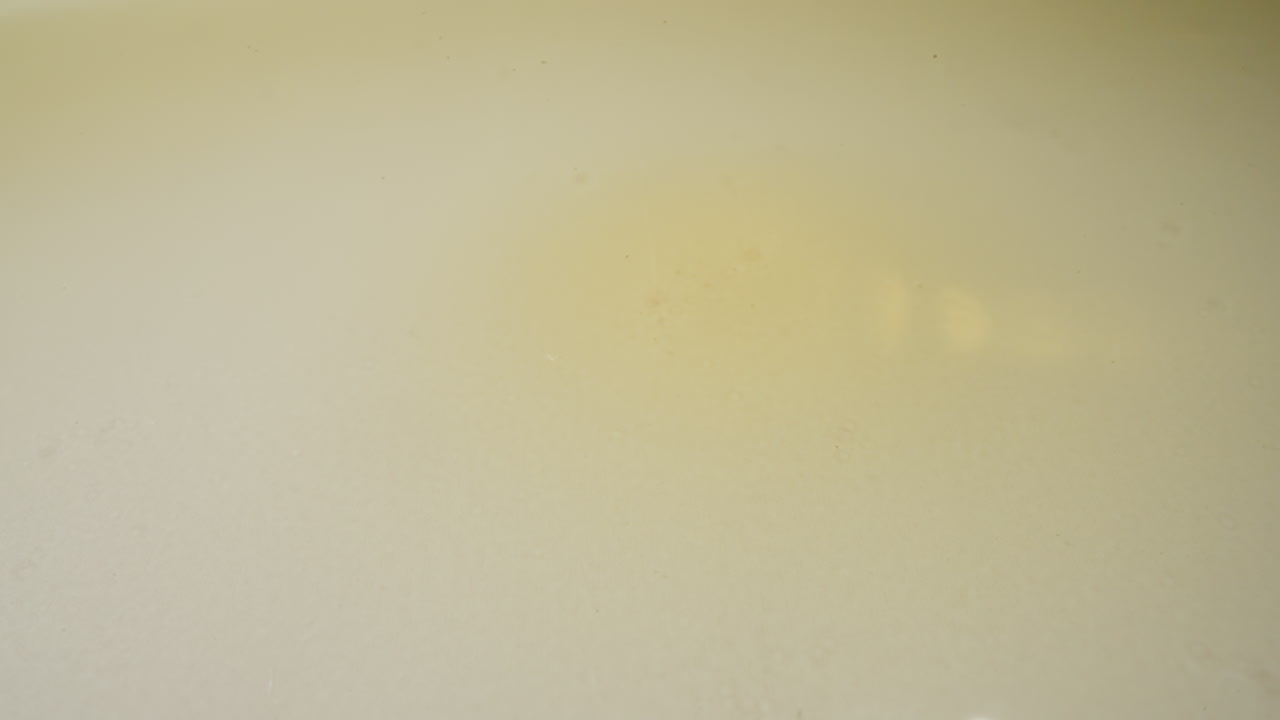 gotas de aceite de jojoba que caen en la superficie y se extienden en charcos