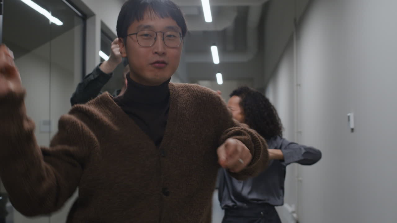 Group of coworkers celebrating success in the office hallway