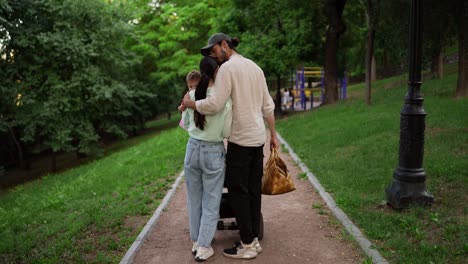 a young family walks through a park together.