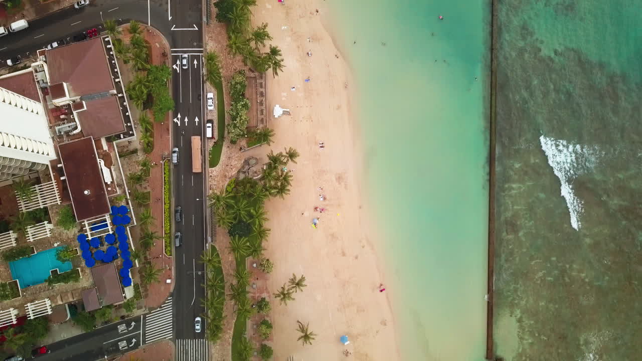 Ripresa aerea dall'alto sopra la spiaggia di Waikiki che segue il traffico sulla strada a Honolulu, Oahu, Hawaii