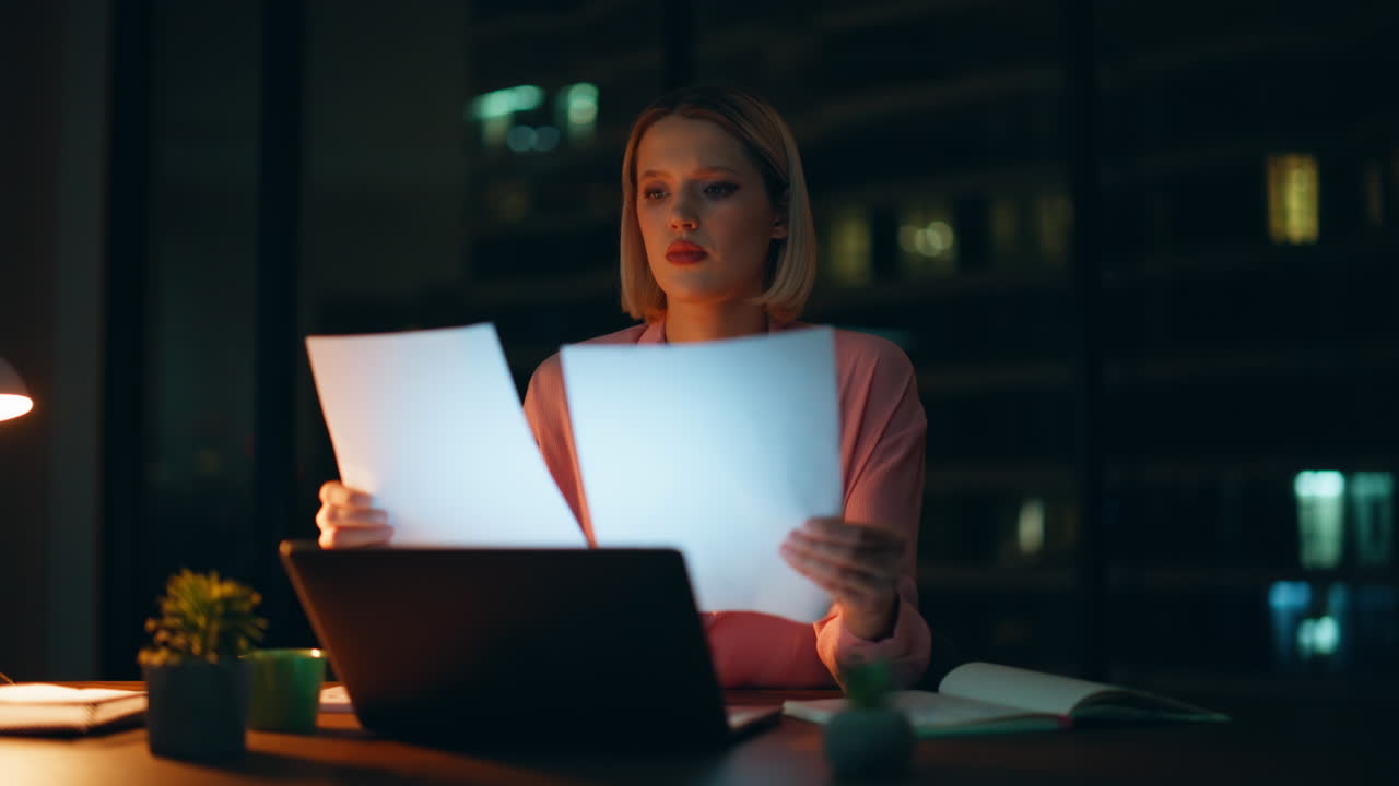 mujer trabajando hasta tarde en la oficina