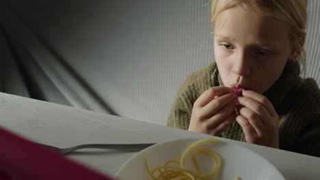 young girl eating spaghetti
