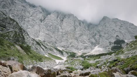 Hohe-Berge,-Wolken,-Die-über-Die-Gipfel-Ziehen,-Wanderer,-Die-In-Der-Ferne-Spazieren-Gehen