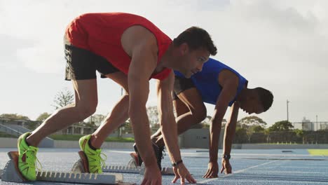 Side-view-of-two-athletes-beginning-race-in-stadium