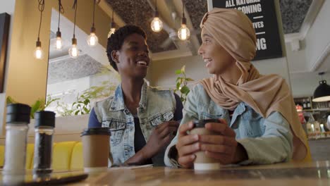 young adult female friends hanging out in a cafe