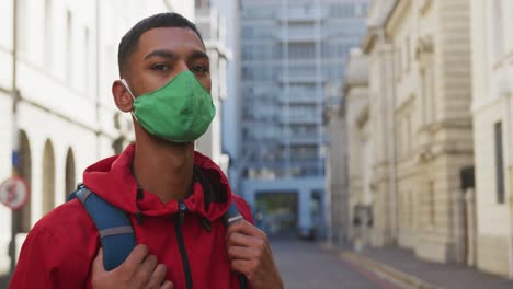 hombre de raza mixta con máscara facial en la calle