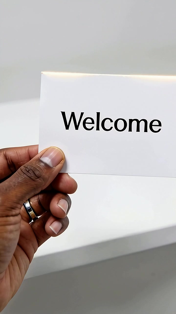 Vertical video: Entering male hand presenting white card at counter, revealing Welcome with rings
