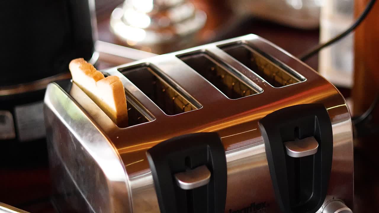 손으로  조각을 토스터에 넣는 것