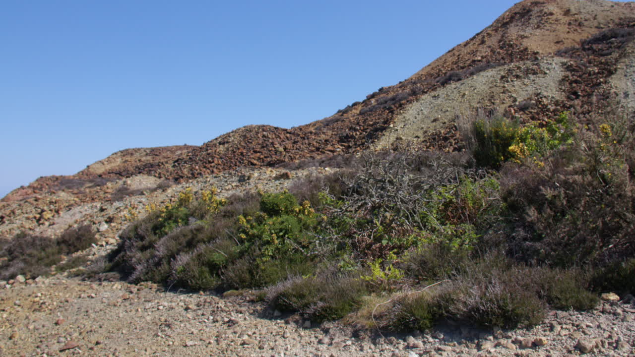 Slow zoom out from the roasted ore slag heap at mynydd parys mountain copper mine