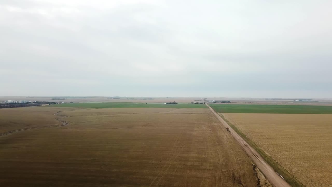 Luftfoto der afslører en hvedemark og en grusvej i det tidlige forår i landlige Nebraska, USA.