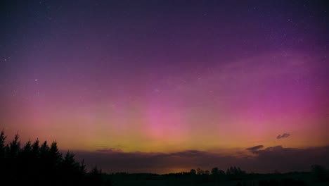 beautiful aurora borealis colors over countryside landscape. stargazing timelapse of glittering stars and northern lights. magical nature phenomenon in the sky.