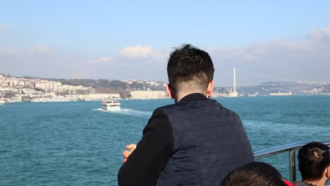 man looks at cityscape from the ship