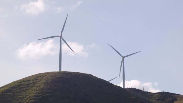 Due turbine eoliche che girano su una collina in Nuova Zelanda