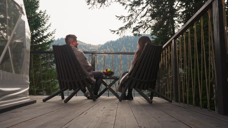 Couple Relaxing on a Mountain Cabin Porch with a Lake View