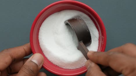 measuring salt in a red bowl