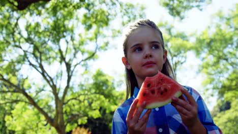 Niña-Sosteniendo-Una-Rodaja-De-Sandía-En-El-Parque-4k