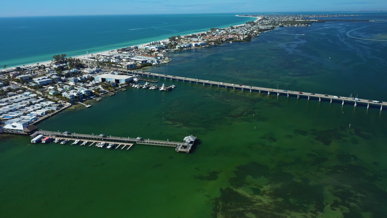Bradenton Beach bridge spanning turquoise waters, connecting a vibrant coastal town. Ideal for travel and infrastructure themes.