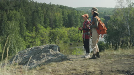 two asian female tourists hiking with trekking poles