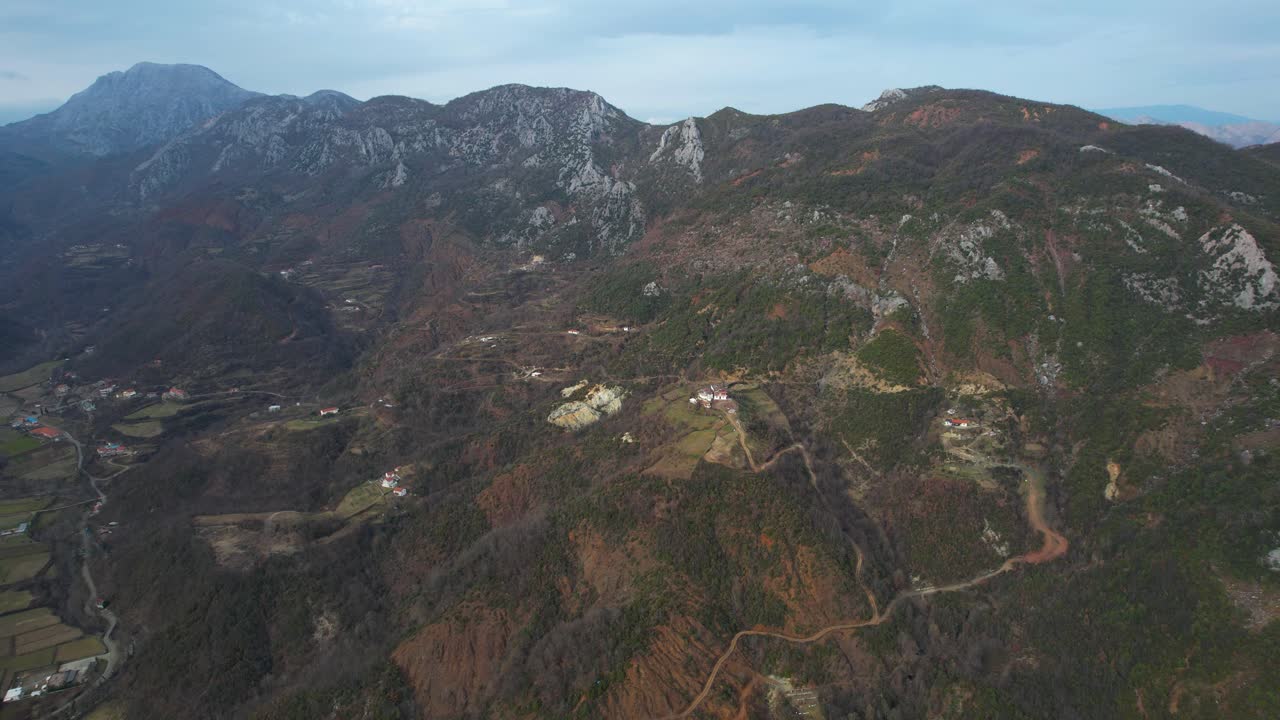 가파른 경사면과 계곡에 집들이 있는 바위 산맥, 알바니아 북부의 풍경