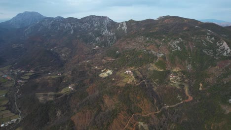 Cordillera-Rocosa-Con-Pendientes-Pronunciadas-Y-Casas-En-El-Valle,-Paisaje-En-El-Norte-De-Albania