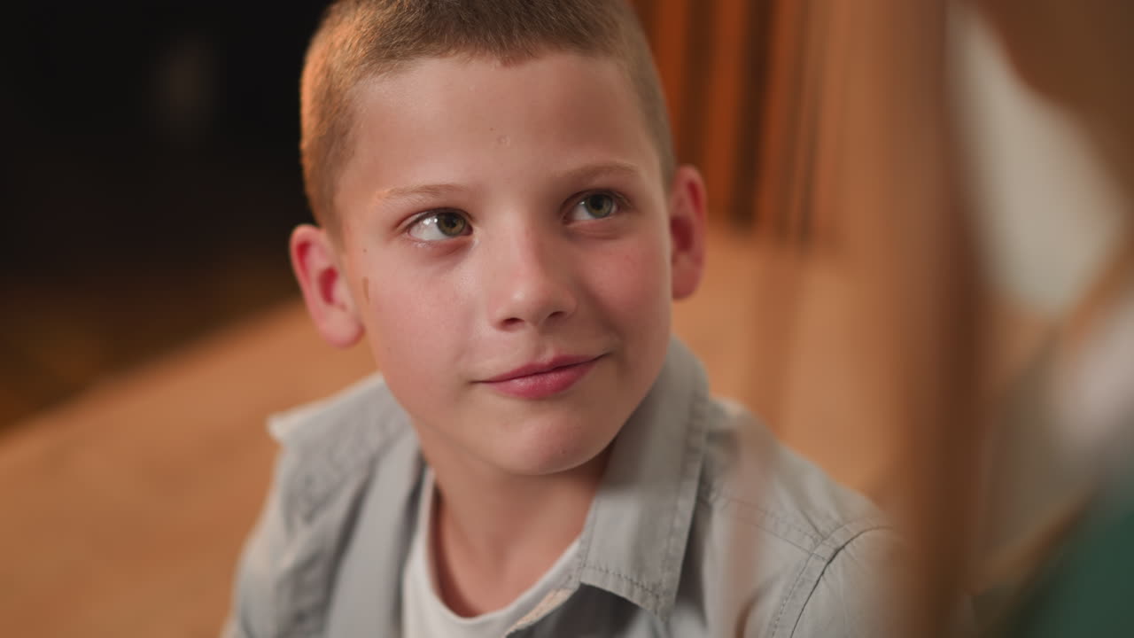 веселый школьник смотрит на молодую женщину с дружелюбной улыбкой.