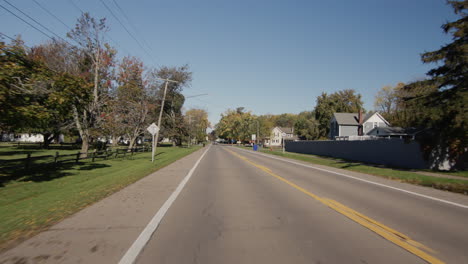 Driving-straight-on-a-flat-road-in-a-typical-American-agricultural-region.-Rear-view