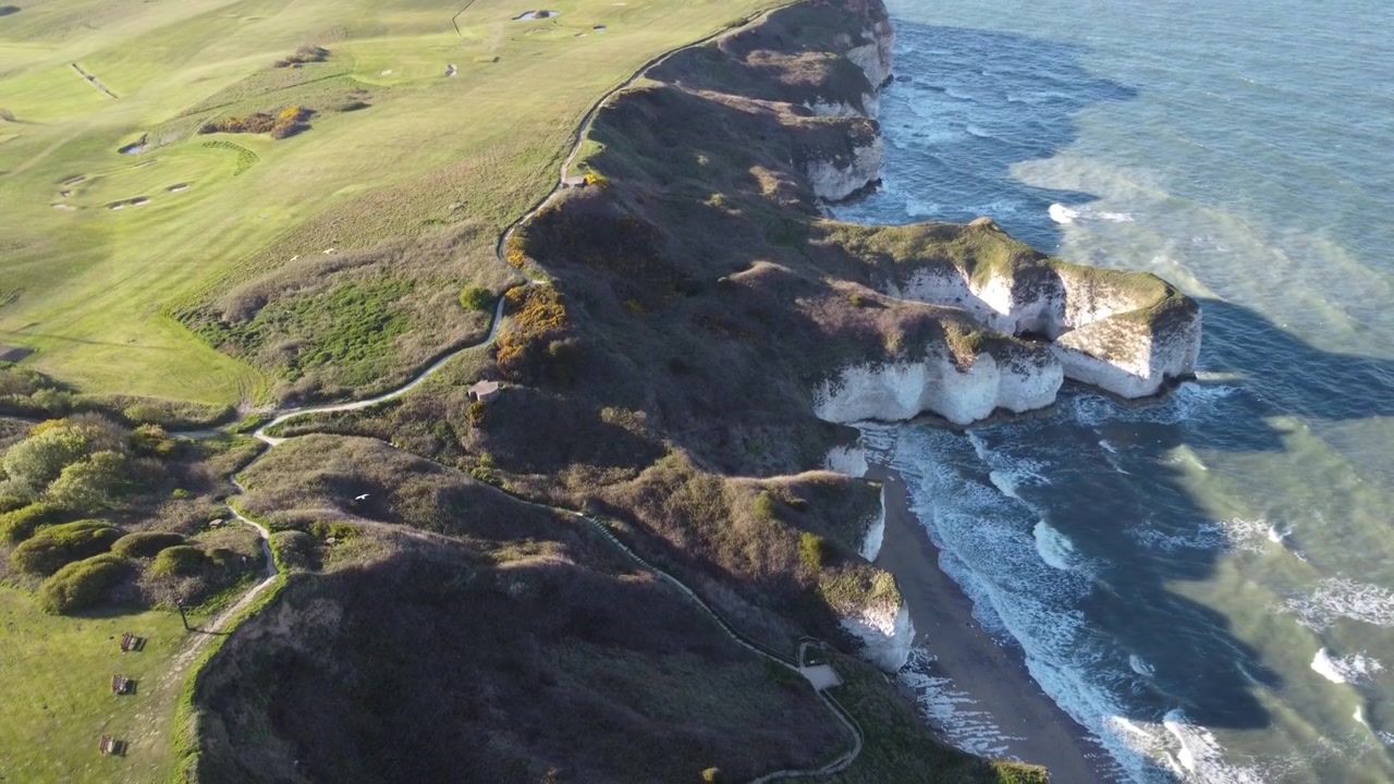 Dramaattinen ilmakuva dronella Flamborough Headista, esitellen jylhiä liitukallioita, turkoosia merta ja upeaa Yorkshiren rannikkoa ylhäältäpäin. Ihanteellinen matkailu- ja luontoprojekteihin.