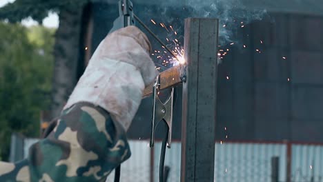 slow motion closeup builder welds fence with new equipment