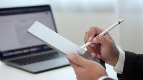hombre de negocios que usa un lápiz estilográfico firmando un contrato en una tableta digital en el trabajo en la oficina en el interior. escriba a mano el acuerdo de negocios del contrato. firma electrónica en una computadora tableta.