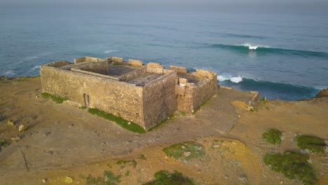 matiz amanecer del fuerte de guincho en la costa de lisboa con algunas olas rompiendo en el fondo, portugal