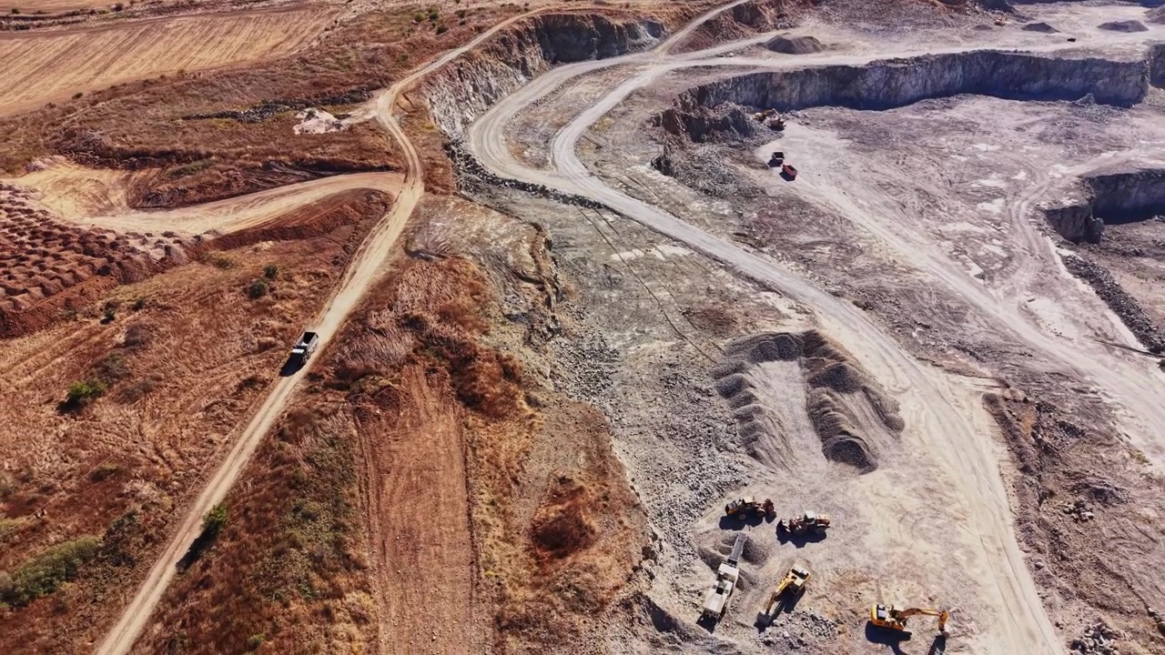 Construction work at a quarry site on a sunny day in a rural area
